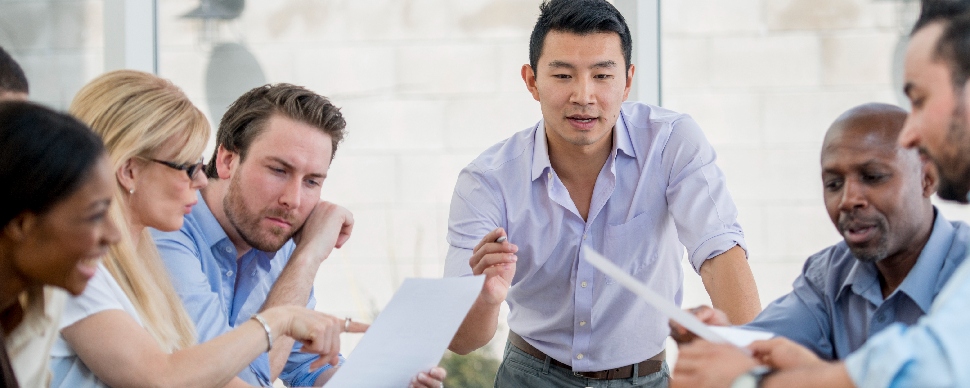 Gruppo diversificato di professionisti impegnati in una discussione in ufficio.