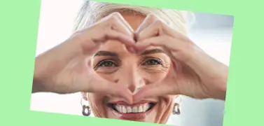 Una donna che forma un cuore con le mani