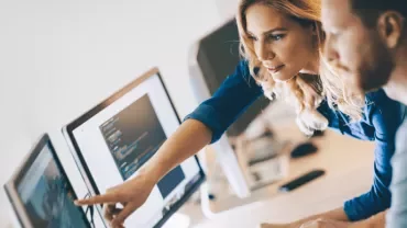 Due persone collaborano davanti a un computer.