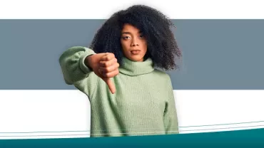 Persona con maglione verde mostra pollice verso.