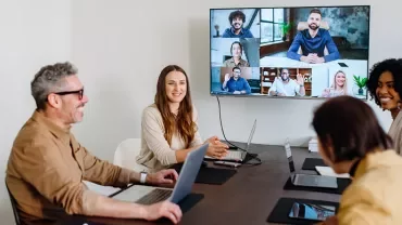 Un team di lavoro ibrido in meeting, che sfrutta competenze di leadership per aumentare la produttività dei dipendenti.
