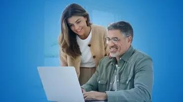 Due professionisti di un'azienda familiare seduti alla scrivania mentre guardano dei dati al PC
