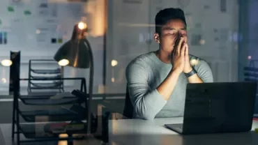 Professionista al PC che riflette sul suo work life management