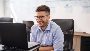 Professionista sorridente lavora al PC