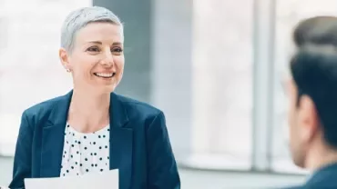 Un professionista a colloquio sottopone alla recruiter il proprio curriculum
