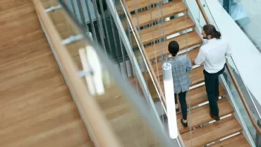 Due professionisti salgono a piedi le scale dell'ufficio