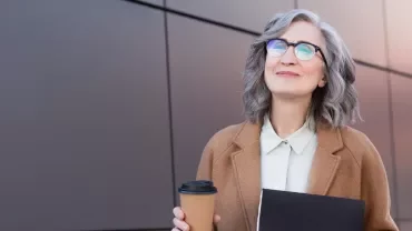 Professionista senior sorridente con caffè