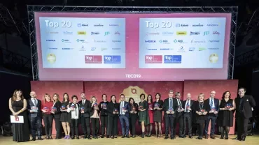 Gruppo di persone premiate su un palco, sfondo con loghi di aziende.