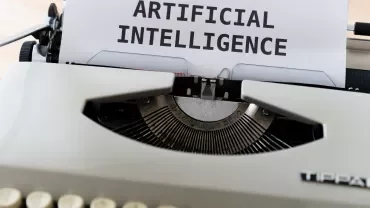 Macchina da scrivere con foglio che dice 'ARTIFICIAL INTELLIGENCE'.