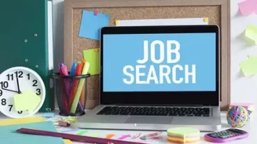 Laptop su scrivania con testo 'Job Search' sullo schermo.