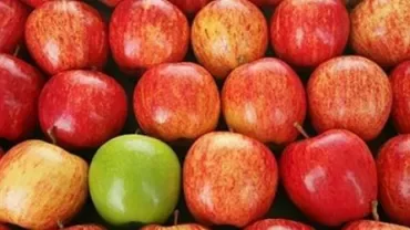 Mele rosse con una mela verde al centro.