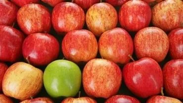 Mele rosse con una mela verde al centro.