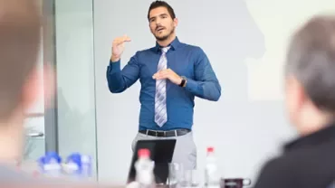 Persona che parla durante una presentazione in ufficio.