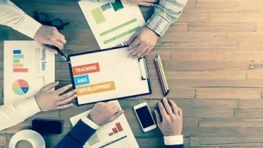 Persone discutono grafici e documenti su un tavolo.