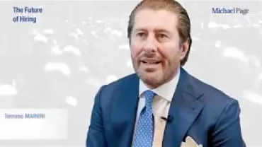 Persona in abito blu in un'intervista.