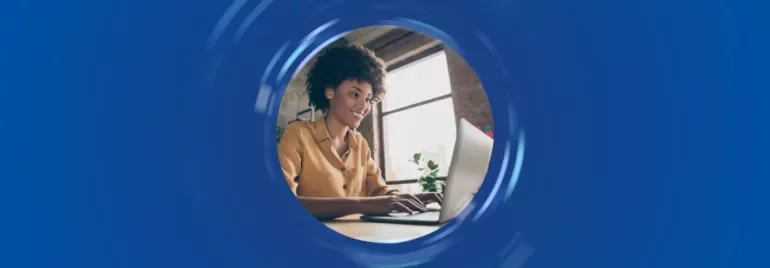 Persona sorridente al computer in una stanza illuminata