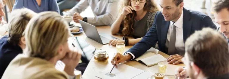 Riunione di lavoro con persone sedute intorno a un tavolo.