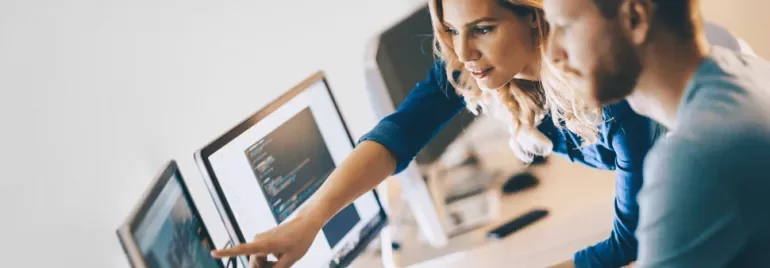 Due persone collaborano davanti a un computer.