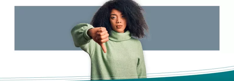 Persona con maglione verde mostra pollice verso.