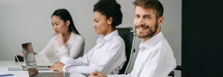 Tre persone lavorano al computer in ufficio.
