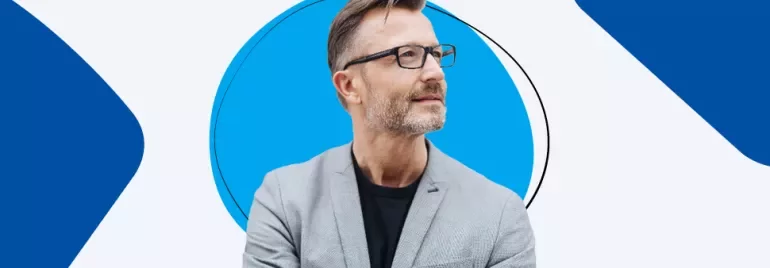Persona con occhiali e barba corta guarda a sinistra.