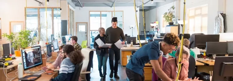 Ufficio moderno con professionisti al lavoro, impegnati in una sessione di mentoring