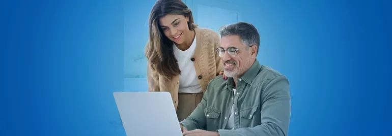 Due professionisti di un'azienda familiare seduti alla scrivania mentre guardano dei dati al PC