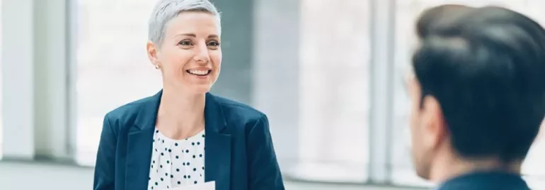 Un professionista a colloquio sottopone alla recruiter il proprio curriculum