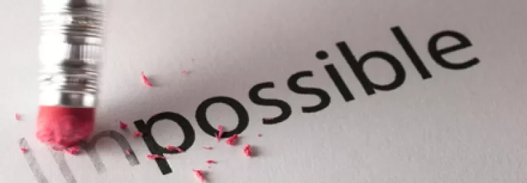 Matita che cancella la parola 'impossible' su carta.