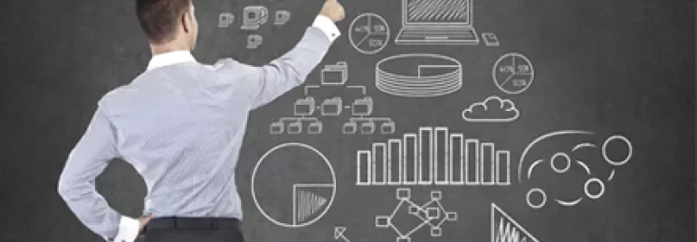 Persona davanti a una lavagna con disegni di grafici e la parola 'Success'.