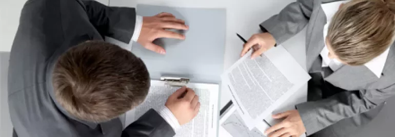 Due persone esaminano documenti in un ufficio.