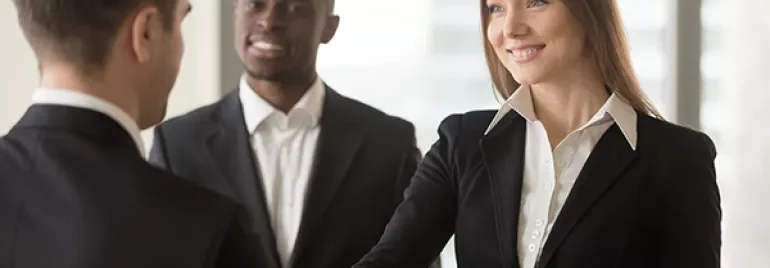 Persone in abiti formali si stringono la mano.