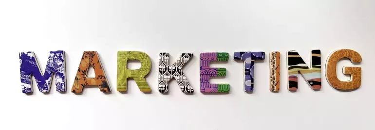 Lettere colorate che formano la parola marketing su sfondo bianco.