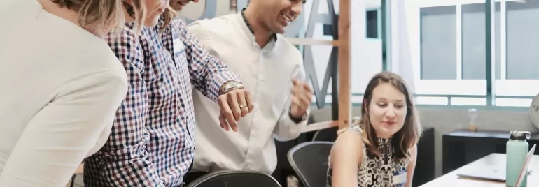 Gruppo di persone che lavora insieme a un laptop.