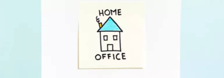 Mano tiene disegno con casa e scritta 'Home Office'.