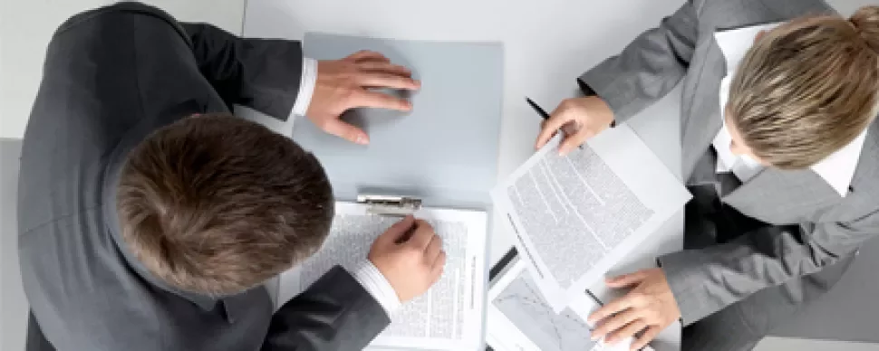 Due persone esaminano documenti in un ufficio.