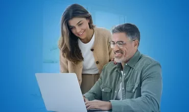 Due professionisti di un'azienda familiare seduti alla scrivania mentre guardano dei dati al PC