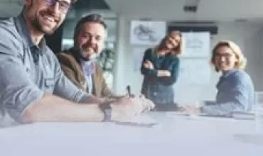 Gruppo di persone sorridenti in una riunione di lavoro.