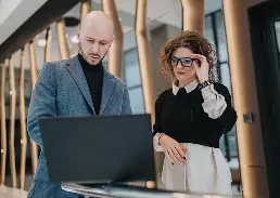 a worker and a client looking at a laptop