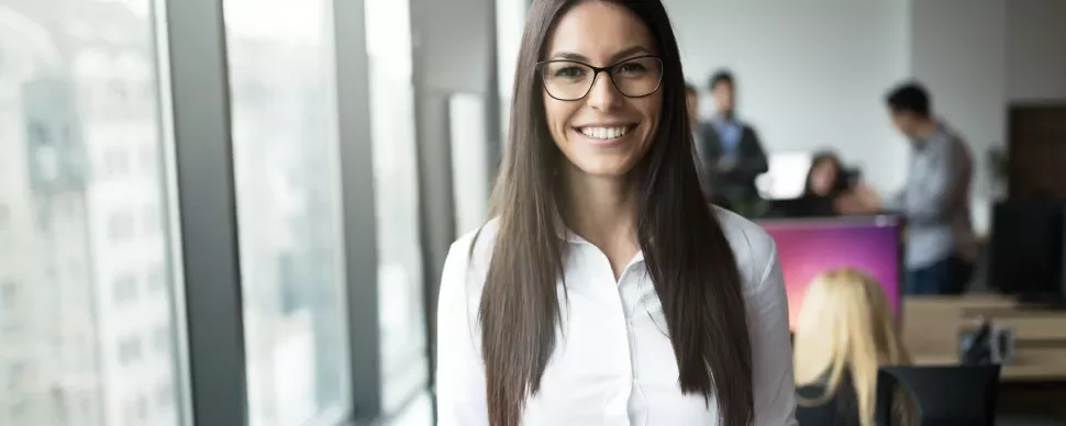 Persona in ufficio, sorridente di fronte alla telecamera