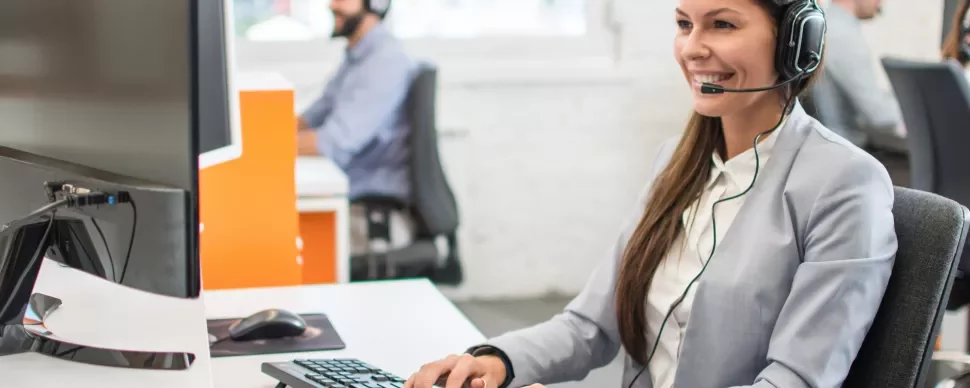 Operatore al computer con cuffie in un ufficio moderno.