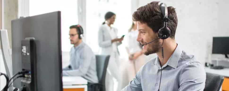 Operatore al computer con cuffia in un ufficio.