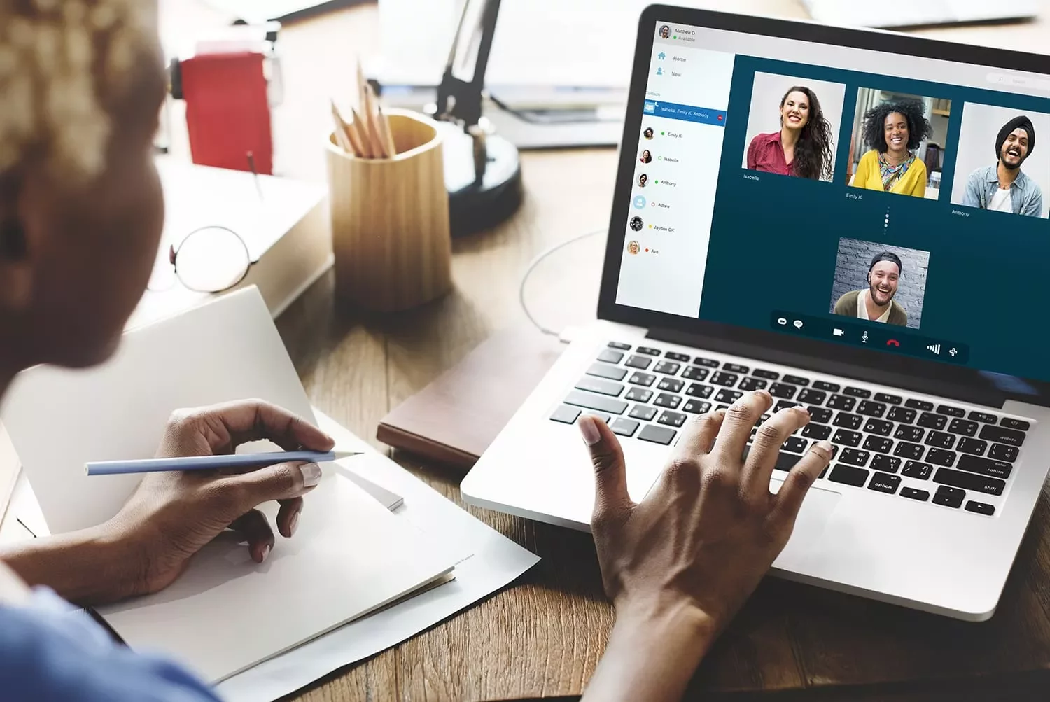Persona che partecipa a una videochiamata su laptop con appunti.