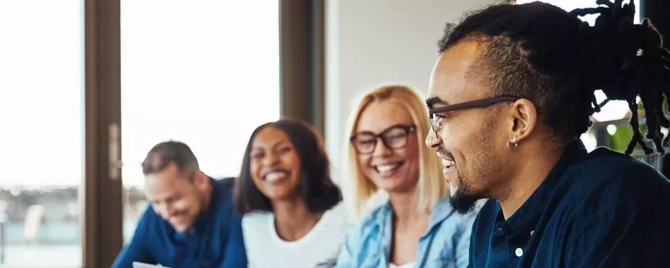 Gruppo di persone che sorridono durante una riunione.