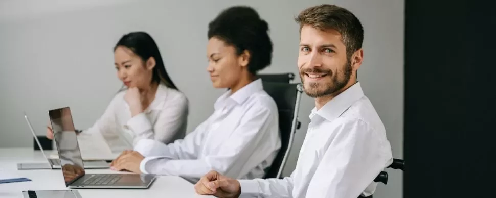 Gruppo di persone al lavoro in ufficio con computer portatili.