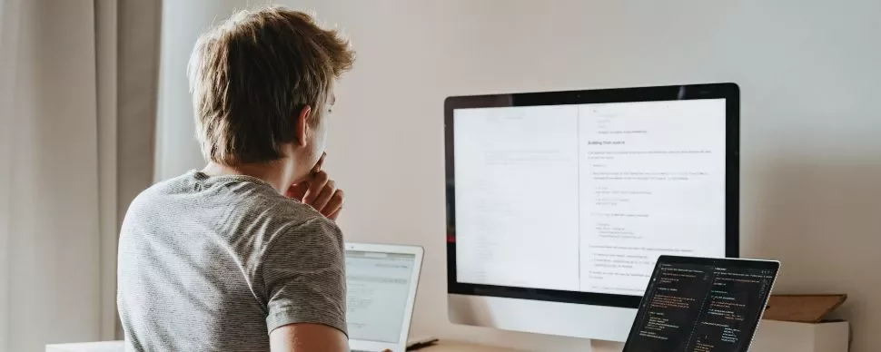 Persona che lavora al computer in un ufficio illuminato.