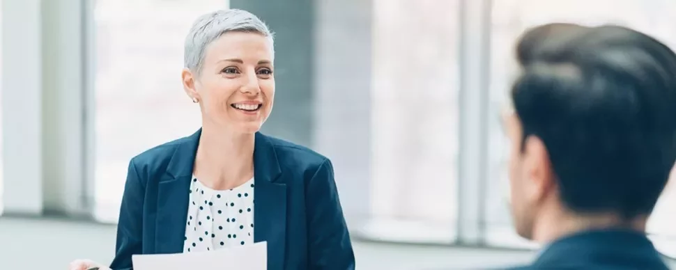 Un professionista a colloquio sottopone alla recruiter il proprio curriculum