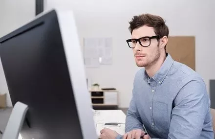 Persona seduta davanti a un computer che guarda lo schermo.