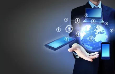 Persona in giacca con dispositivi digitali fluttuanti sopra una mano.