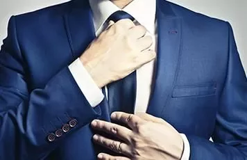 Persona in abito blu sistema la cravatta.